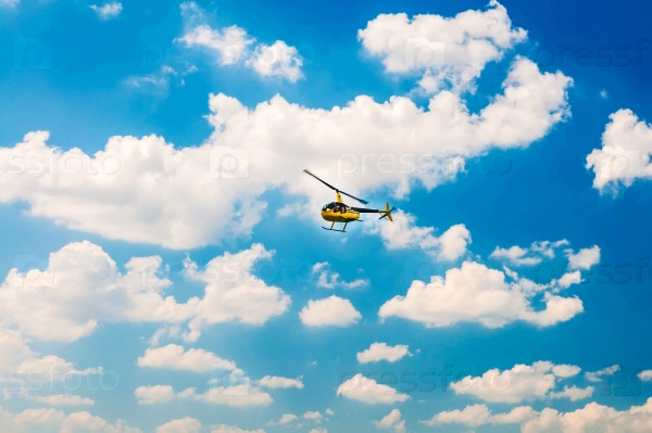Yellow tourist Helicopter in the blue sky, stock photo