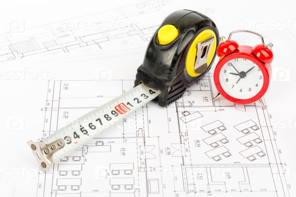 Tape measure with red alarm clock on draft background, stock photo