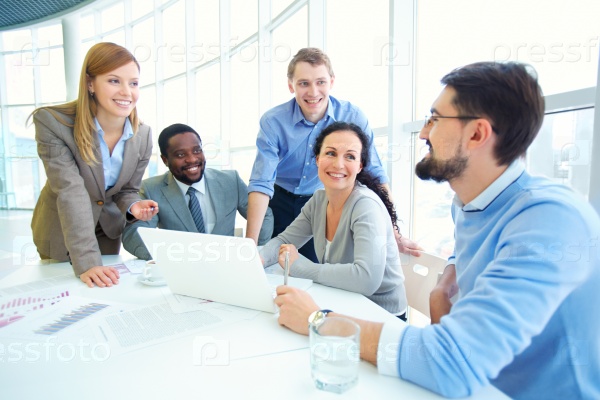 Group of managers looking at their colleague explaining data, stock photo