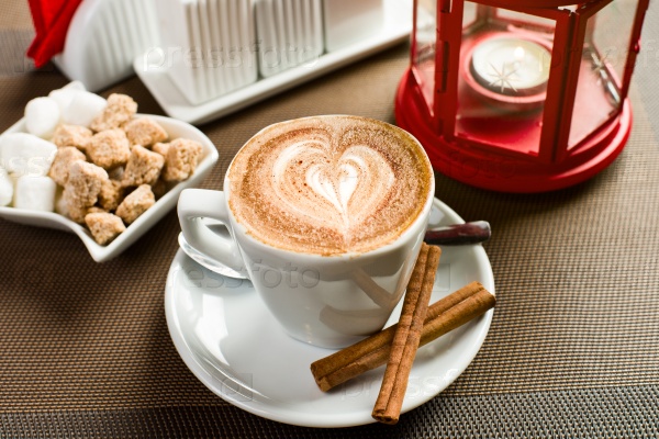 white cup with coffee - cappuccino,  on table in coffee house, close up