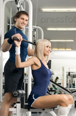 girl and guy,  execute exercise on sport-apparatus , in  sport-hall