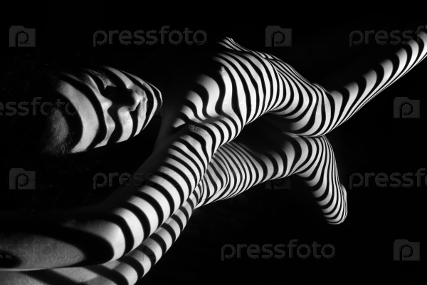 The nude woman and her reflection with black and white zebra stripes.  Black-and-white photo created with the projector