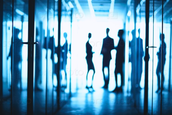 Silhouettes of business people standing in corridor of business center