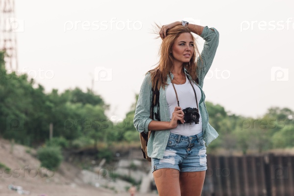Girl takes photographs with vintage photo camera outdoor, stock photo