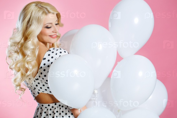 Fashion photo of beautiful woman with balloons. Girl posing. Studio photo. Attractive blonde elegant woman with balloons over pink background.