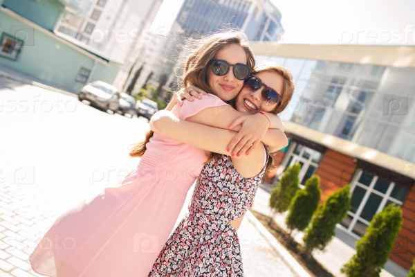 two girls friends laughing and hugging. hug and smile outdoor
