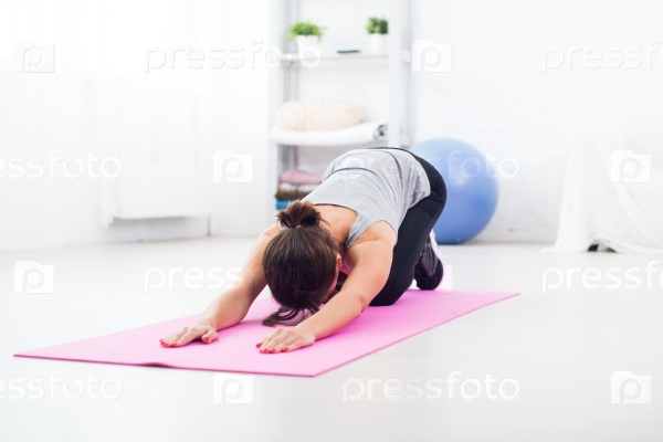 Fit woman bending over on mat