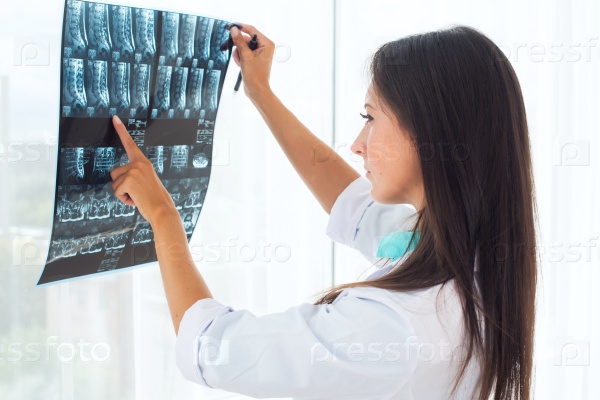 Stock Photo: Woman doctor in hospital looking at x-ray film healthcare, roentgen, people and medicine concept.