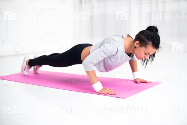 Stock Photo: Young latin woman warming up and doing push ups at home fitness healthy lifestyle diet concept.