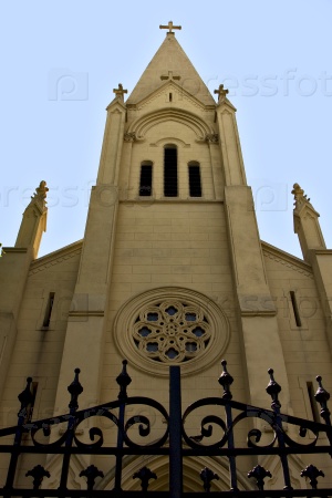 the yellow brick facade rose window and blue sky    in the church buenos aires argentina