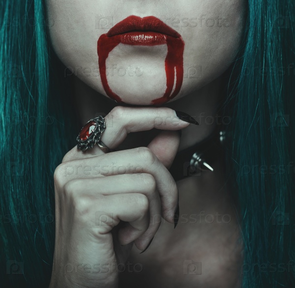 Beautiful vampire woman, red lips in blood, close-up. Halloween or horror theme
