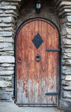 Старая деревянная дверь с кованой ручкой-колотушкой