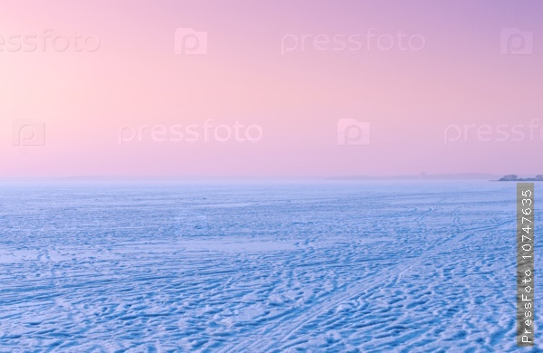 Amazing pink sunset on the frozen sea in winter time