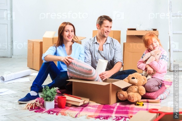 The happy family at repair and relocation. The family planing to accommodation on a background of boxes, stock photo
