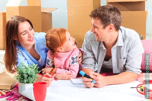 The happy family at repair and relocation. The family planing to accommodation on a background of boxes, stock photo