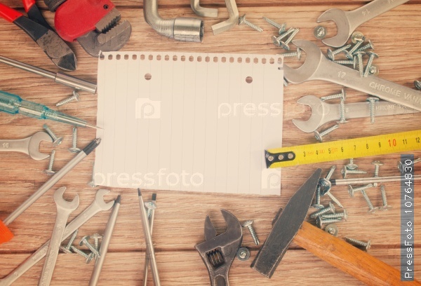 Empty note with tools kit on parquet plank, retro toned, stock photo