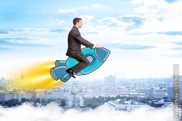 Businessman flying on drawn rocket above city, stock photo