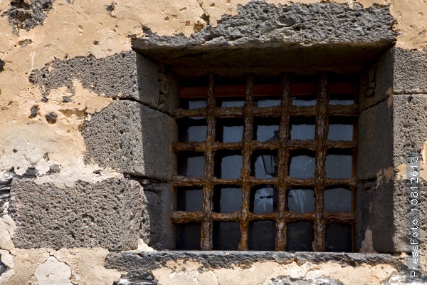 Brown distorted castle window in a broke wall arrecife