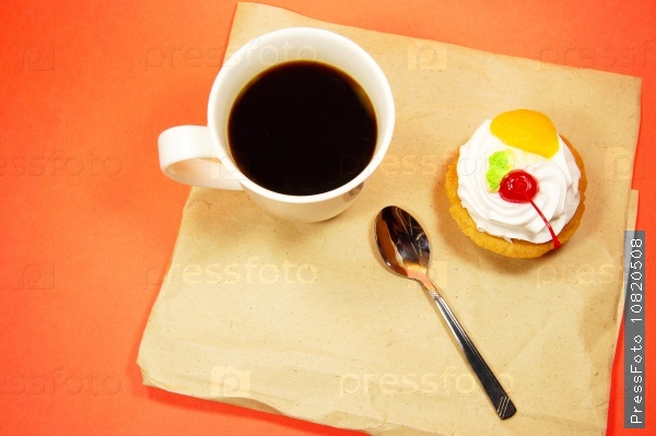 cup of coffee and fruit cake on a paper on a red background