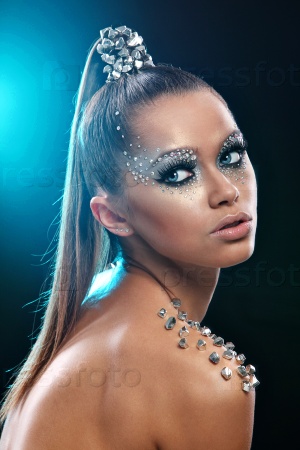 Portrait of woman with artistic make-up and rhinestones over background