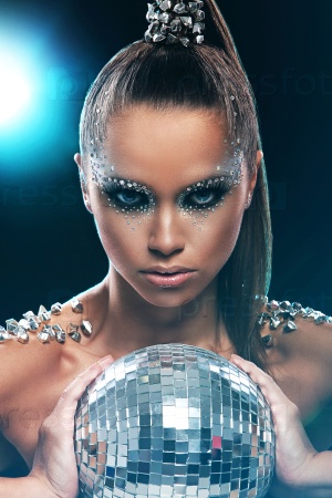 Portrait of woman with artistic make-up and rhinestones over background