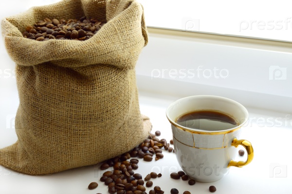 cup of aromatic coffee and the coffee beans