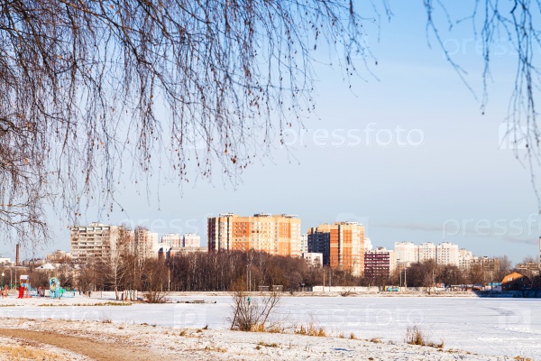 Frozen lake and urban houses in cold winter day, stock photo