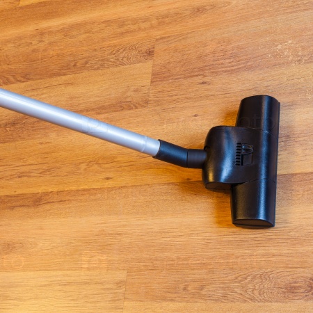 Washing of laminate floor by vacuum cleaner at home, stock photo