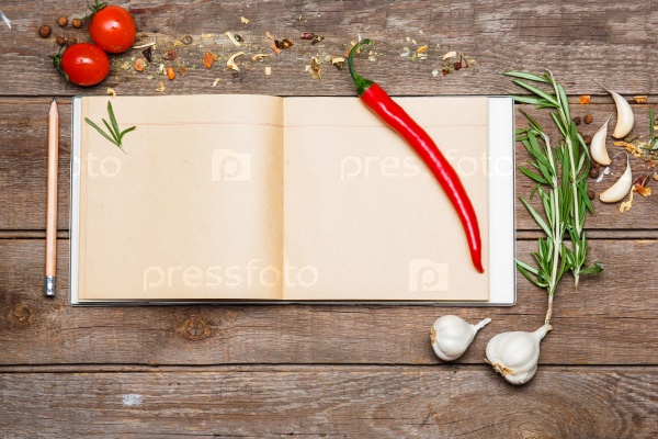 Open blank recipe book on brown wooden background wits, garlic, red hot peppers, stock photo