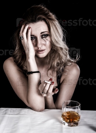 Depressed young woman with a glass of whiskey and a cigarette over black background