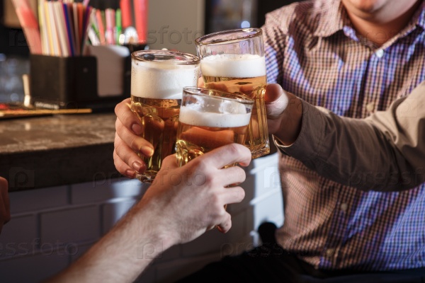 Happy smiling friends drinking beer at counter in pub, stock photo