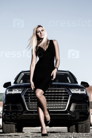 Gorgeous business lady at the background of the modern luxury car