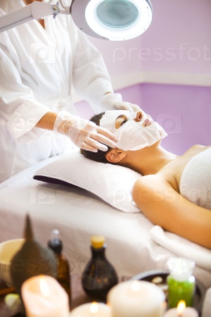 Beautiful brunette woman getting a facial treatment at the health spa