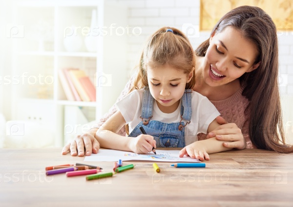 Happy family. Mother and daughter together paint. Adult woman helps the child girl, stock photo