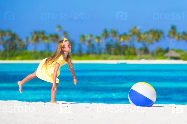 Little adorable girl playing with air ball outdoor on beach