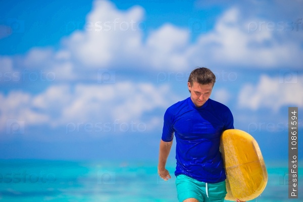 Happy young surf man at white beach with yellow surfboard