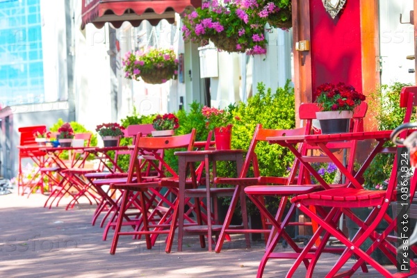 Red tables and chairs at a sidewalk cafe at european city