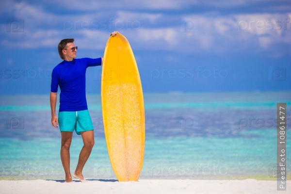 Happy young surf man at white beach with yellow surfboard