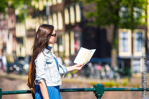 Happy young woman with a city map and backpack in Europe