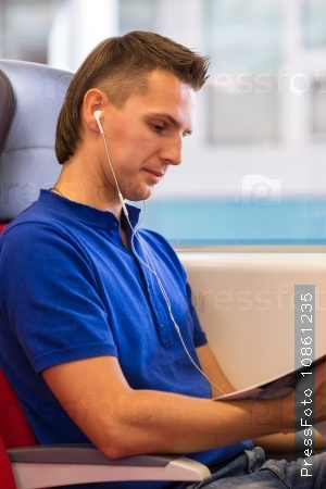 Young happy man listening music traveling by train