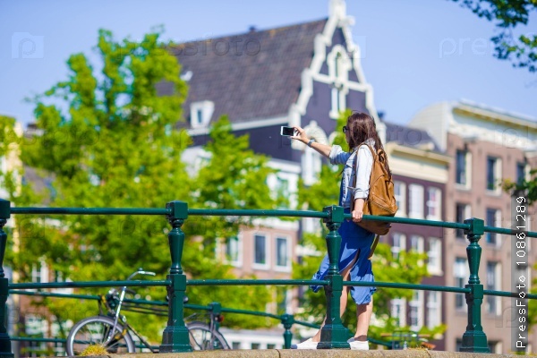 Young woman tourist taking self portrait selfie photo on Europe travel in Amsterdam city