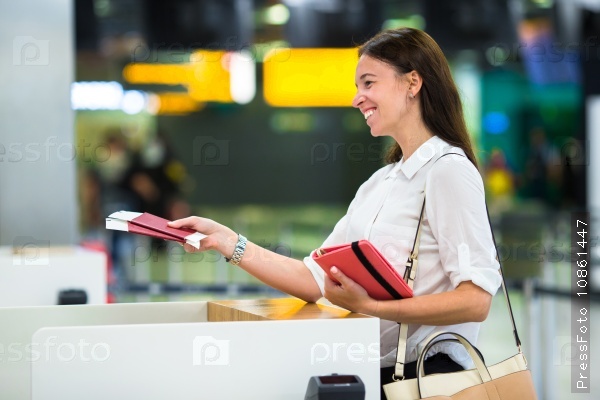 Young girl with passports and boarding passes at the front desk at international airport