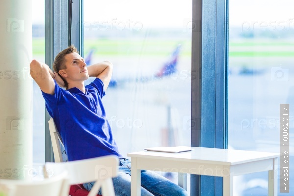 Young caucasian man at airport indoor waiting for boarding