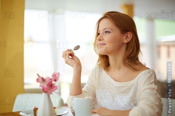 Happy young woman eating dessert in cafe, stock photo