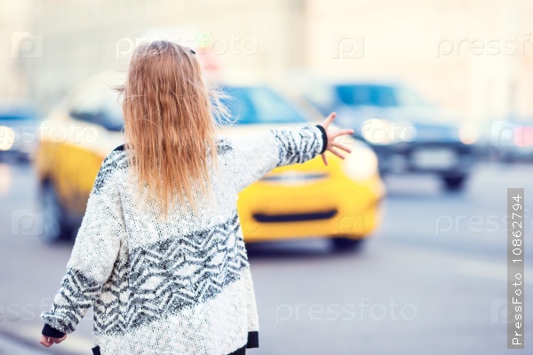 Adorable little girl get taxi outdoors in European city, stock photo