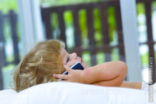 High key portrait of young baby with mobile phone