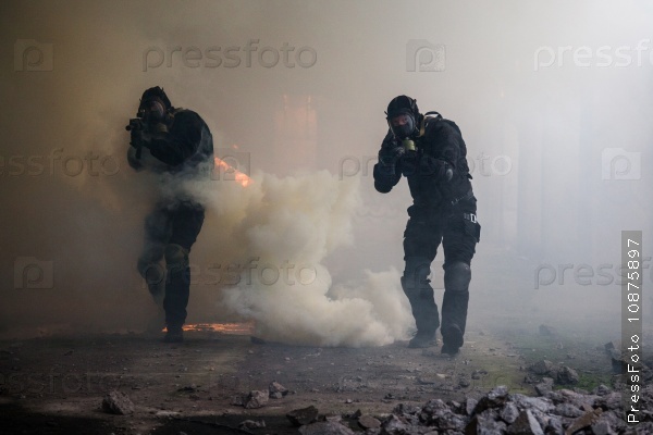 Special forces operator in black uniform in the smoke