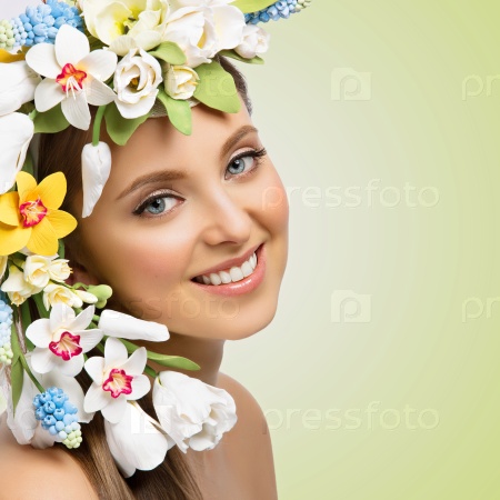 Closeup portrait of beautiful young happy woman with many flowers on head. Isolated over green background. Copy space, Square composition.