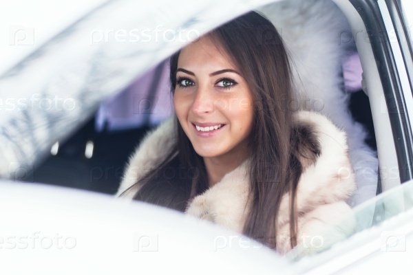 Smiling woman in fur coat sitting in car Winter picture