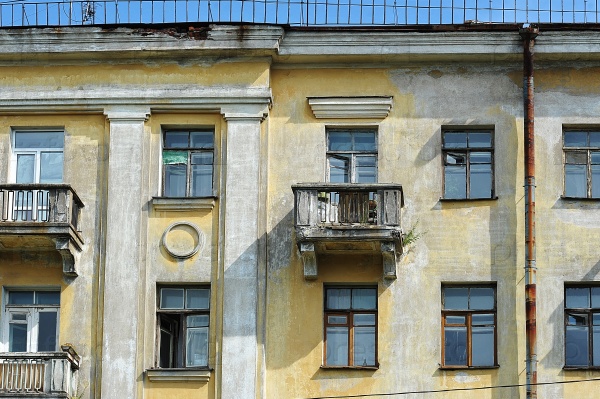 Typical Stalinist old house in St. Petersburg in Empire style with a growing trees on the balcony